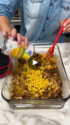 a person pouring corn on the cob into a casserole dish