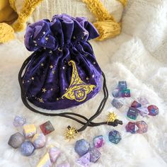 This wizard multi pocket dice bag is made with starry purple velvet and matching plush fabric. It is soft to the touch and will keep your dice nice and cozy. The embroidered design on the front features a large wizard hat with a D20 underneath it. The bag has strong cord drawstrings accented with golden sun charms at the ends.Inner bag space is about 9 x 4.5 inches, plenty of room for several sets of dice, there are 6 inner pockets that will hold 3 to 4 standard dice sets and 1 large middle pocket that can hold about 20 sets. That's a lot of easily transportable and organized dice storage! Wizard Dice, Dice Collection, Wizard Hat, Ritual Tools, Golden Sun, Dice Bag, Plush Fabric, Purple Velvet, Velvet Bag