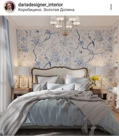 a bed sitting in a bedroom next to a wall with flowers on it and a chandelier hanging from the ceiling