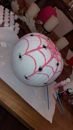 a large white ball covered in spider webs on top of a table next to candles