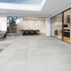 an open living room and dining area with skylights on the roof, glass doors leading outside