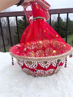 This is our stunning gift basket that will add the perfect and most unique touch to any event. It comes in a beautiful red color and is embellished with sequins. This basket also comes with a bangle matching that encloses the net when something is placed inside. The tray is lightweight but sturdy and is sure to last a lifetime as a keepsake. It can be used in multiple ways: to hold clothing, jewelry, sweet treats, candy, and also accessories.   It also comes with a matching bangle to enclose the net on top. We can re-create this same piece with a different color to match your outfit and can also switch the borders to your liking! We can also make more of the same item if you need more than one piece.  * PERSONALIZED DESIGN VARIES DEPENDING ON THE AVAILABILITY OF THE RAW MATERIALS. PROCESSI Blue Gift Basket, Colorful Basket, Hamper Gift Basket, Indian Wedding Decor, Red Basket, Colorful Baskets, Henna Cones, Clothing Jewelry, Hamper Basket