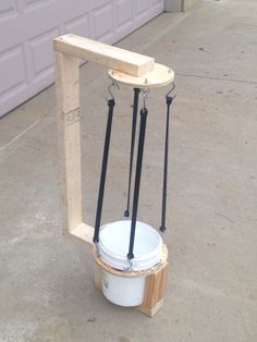 a white bucket sitting on top of a wooden stand next to a garage door with two black handles