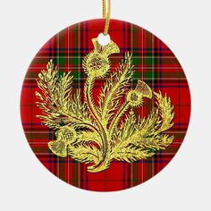 a christmas ornament with gold thistle on a red tartan plaid round ornament