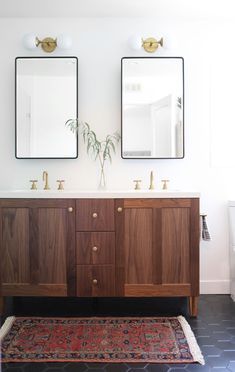 two mirrors are above the double sinks in this bathroom