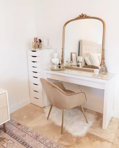 a white desk with a mirror, chair and drawers in a room that is well decorated