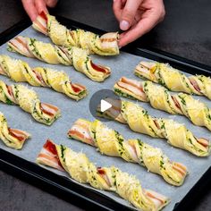 someone is making sandwiches with ham and cheese on a baking sheet in the process of cooking