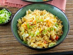 two bowls filled with rice and vegetables on top of a table