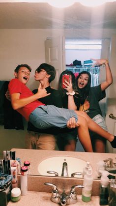 a group of people standing in front of a bathroom sink with their arms around each other