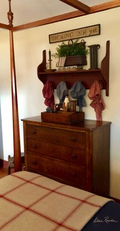 a bed room with a neatly made bed and a wooden dresser