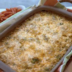 a casserole dish with carrots and broccoli in it on a table