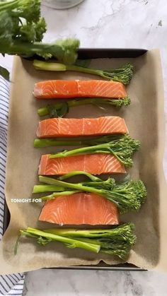 raw salmon and broccoli arranged on a platter ready to be cooked in the oven