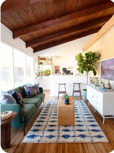 a living room filled with furniture and a large rug on top of a hard wood floor