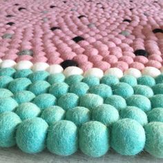 a close up of a rug made out of balls and pom - poms