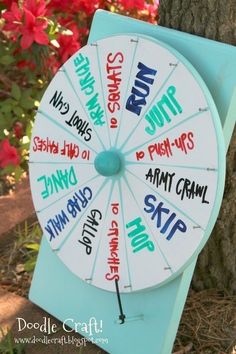 a blue and white clock sitting next to a tree with writing on the front of it