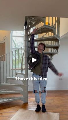 a man standing on top of a wooden floor in front of a spiral stair case