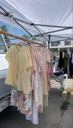 clothes are hanging from a rack under a tent