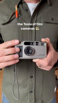 a man holding a camera in his hands with the text, the tesla of film cameras