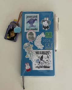 a clipboard with various stickers on it and a keychain attached to it