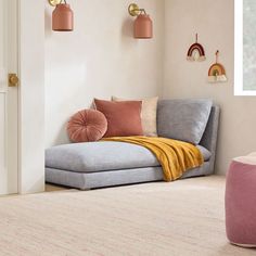 a living room scene with focus on the chaise lounge and pink accessories in the background