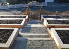 several wooden raised beds filled with dirt