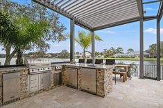 an outdoor kitchen with grill, sink and seating area