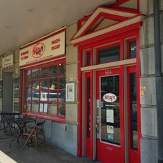 the outside of a restaurant with tables and chairs