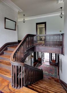 a wooden staircase leading up to the second floor in an old style home with hardwood floors