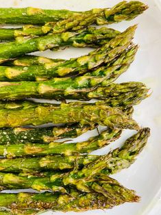 asparagus spears on a white plate ready to be cooked in the oven for dinner