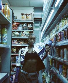 a woman is standing in the aisle of a grocery store