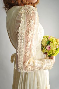 a woman in a white dress holding a bouquet of flowers