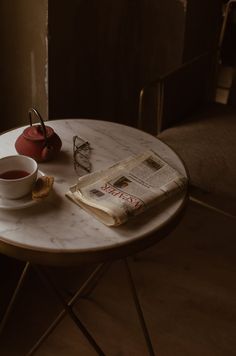 a table with a cup of tea and a book on it