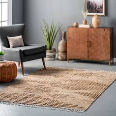 a living room filled with furniture and a large rug on the floor next to a window