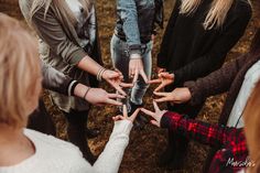 a group of people standing around each other holding hands together in the middle of a circle