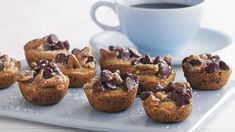 chocolate chip muffins on a plate next to a cup of coffee