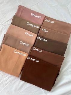 six different colors of bed sheets on top of a white sheeted bed with the names of them