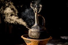 an old tea pot with steam coming out of it