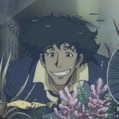 a man with black hair is smiling and holding flowers