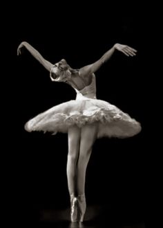 a ballerina in white tutu with her arms outstretched and legs spread out, on a black background