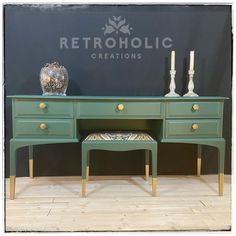 a green desk with two stools and a vase sitting on top of it next to a sign that says retroholic creations