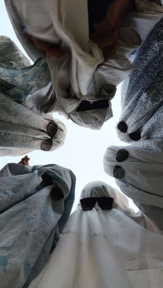 looking up at the top of several beds covered with blankets and eyeglasses in a circle