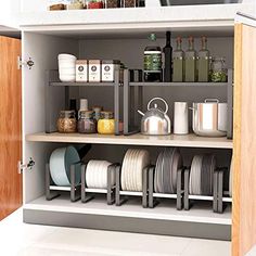 an open cabinet filled with dishes and cups