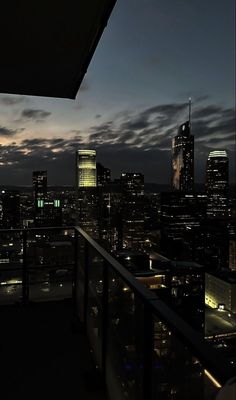 the city skyline is lit up at night, with skyscrapers in the foreground