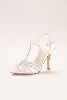 a woman's white high heeled shoe with straps