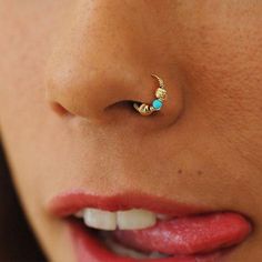 a woman's nose with a gold nose ring and turquoise stone in the middle