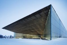 the building is covered in snow and has a large triangular roof over it's entrance