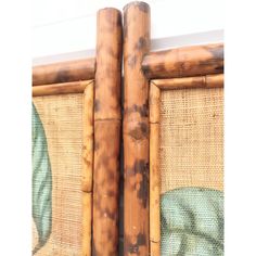 two bamboo poles sticking out of the side of a wall next to a painting on it