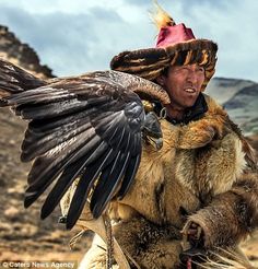 a man dressed in native clothing holding a bird