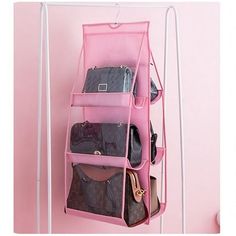 a pink hanging organizer with purses and handbags on it's sides in front of a pink wall