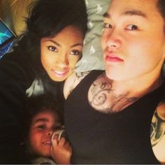 a man and woman laying in bed next to each other with tattoos on their arms